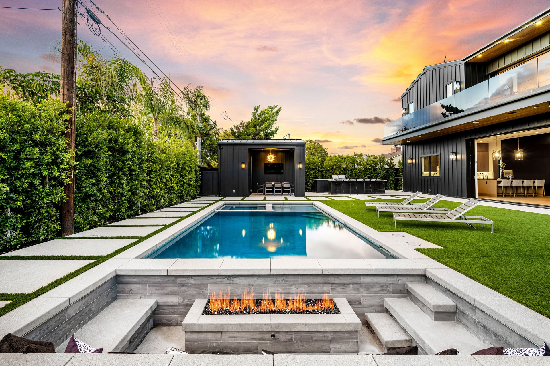 Luxurious backyard with pool and fire pit at sunset